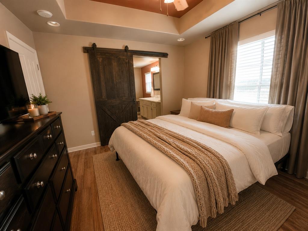 420 Sessums Road Springtown, TX 76082 - Photo 18 of 40 Spacious bedroom featuring wood-finish flooring, a coffered ceiling with a ceiling fan, and a large window with blinds and drapes-virtkually staged.