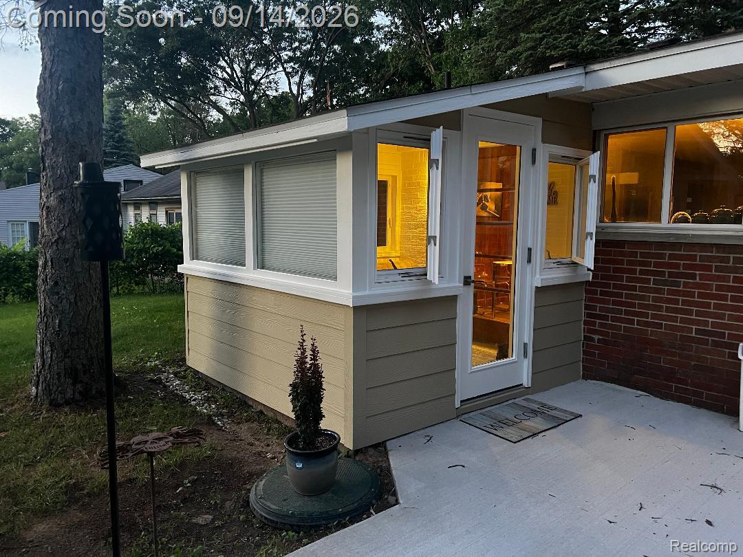 1615 Ladd Road Walled Lake, MI 48390 - Photo 7 of 28 Sunroom extension featuring multiple windows, a glass-paneled entry door, and exterior siding