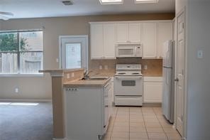 17606 Bering Bridge Lane Humble, TX 77346 - Photo 8 of 8 a kitchen with white cabinets and white appliances