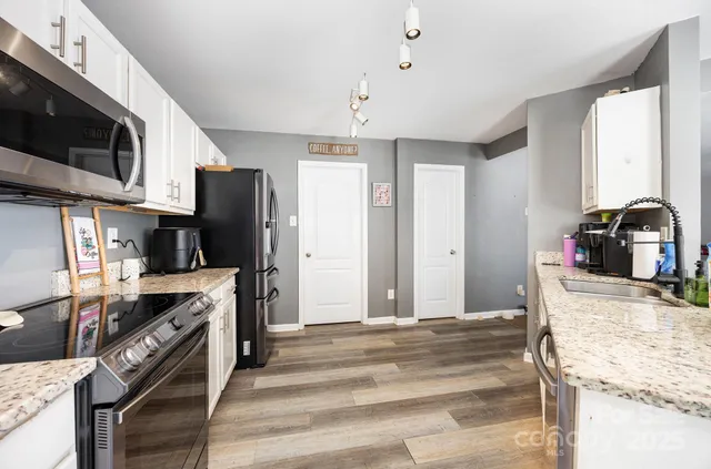 a kitchen with stainless steel appliances kitchen island granite countertop a stove refrigerator and microwave