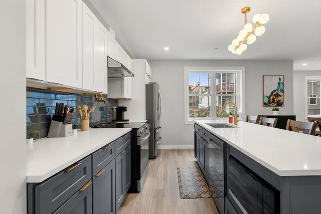 a kitchen with kitchen island a sink appliances and cabinets