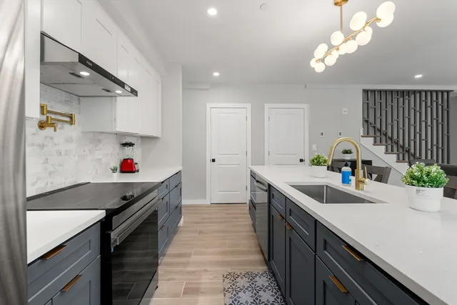 a kitchen with a sink a stove and cabinets