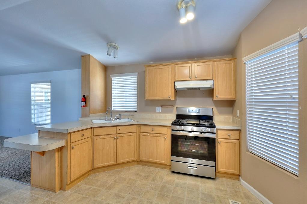 3506 Homestead Way Ceres, CA 95307 - Photo 13 of 39 a kitchen with stainless steel appliances a stove and white cabinets