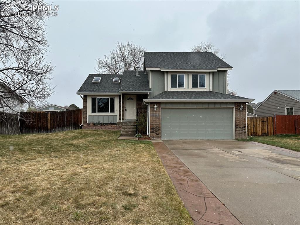2990 Mirage Drive Colorado Springs, CO 80920 - Photo 1 of 36 a front view of a house with a garden and trees