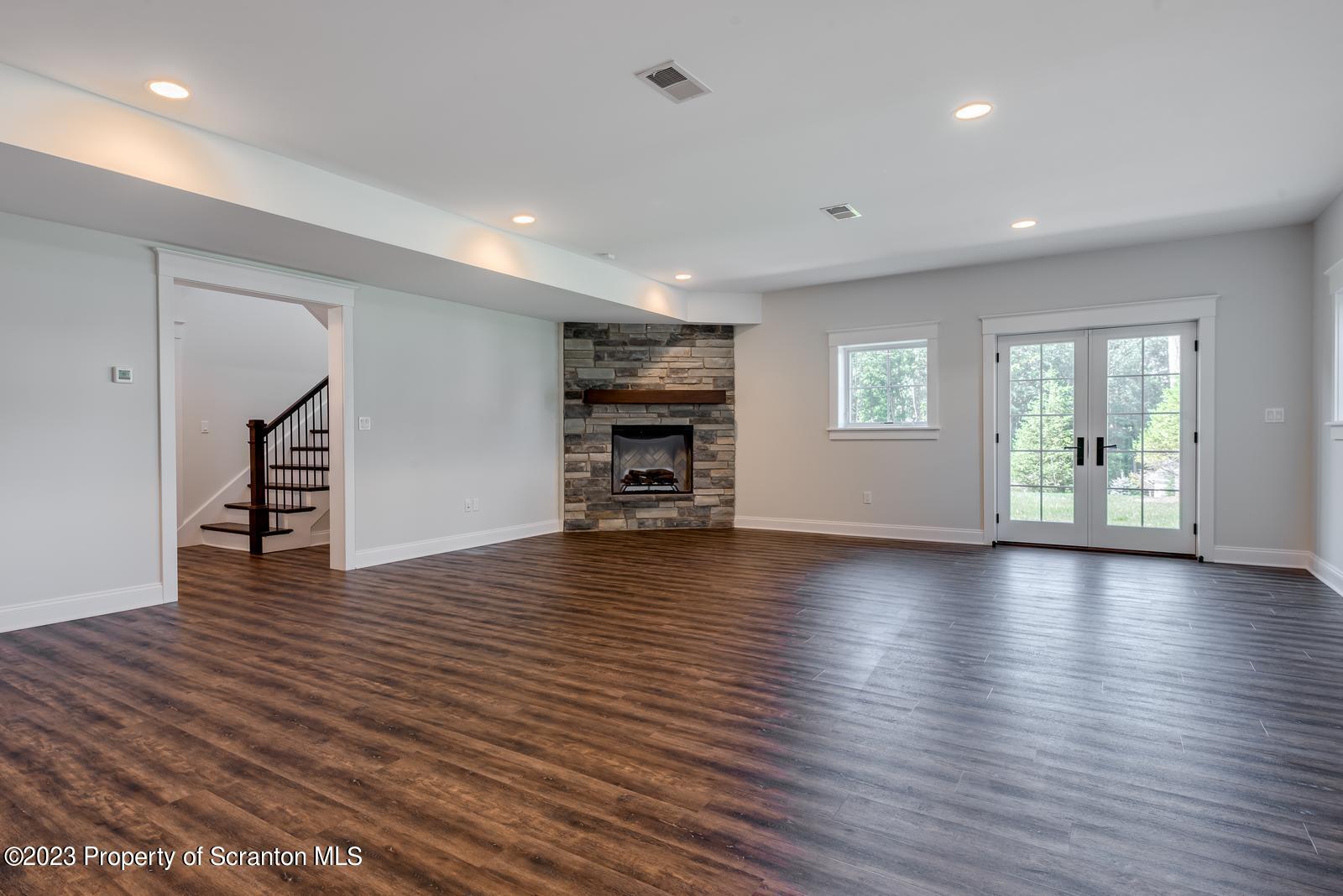 115 Rock Ridge Drive Clarks Summit, PA 18411 - Photo 32 of 43 an empty room with wooden floor fireplace and windows