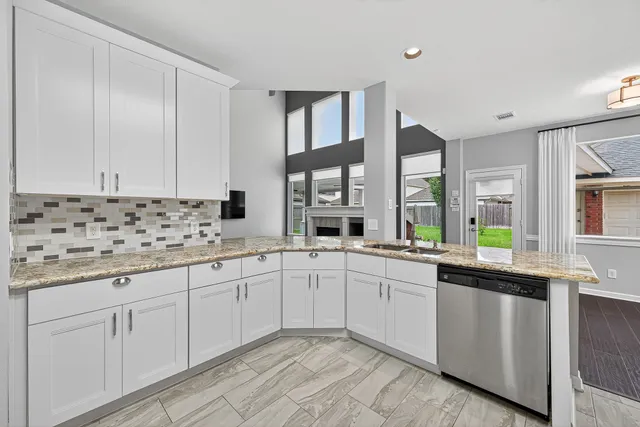 a kitchen with granite countertop a sink and cabinets
