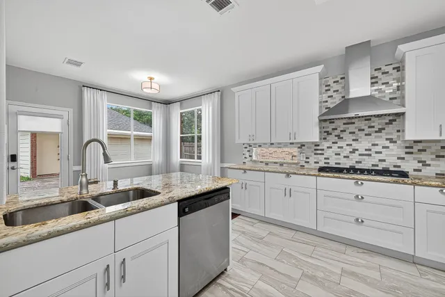 a kitchen with granite countertop a sink and cabinets
