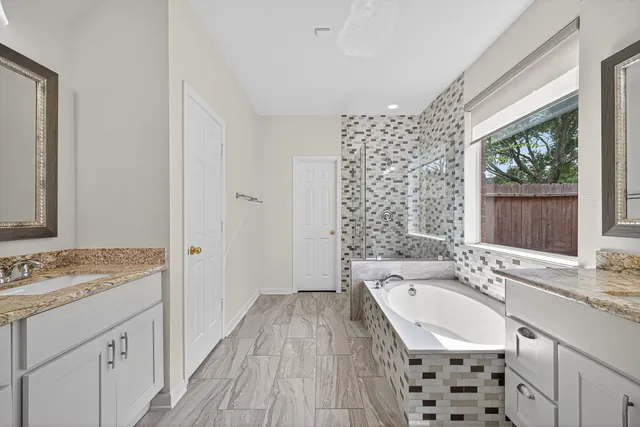 a bathroom with a granite countertop sink a mirror a vanity and a shower