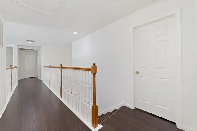 a view of a hallway with wooden floor and entryway