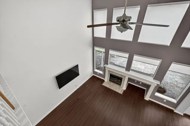 a view of an empty room with wooden floor and furniture