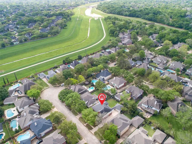 an aerial view of a tennis ground and a large tree