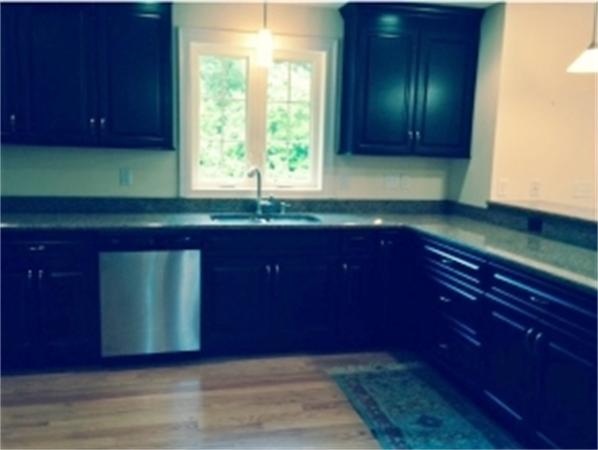 2 Coventry Road Atkinson, NH 03811 - Photo 2 of 10 a kitchen with wooden cabinets and a sink