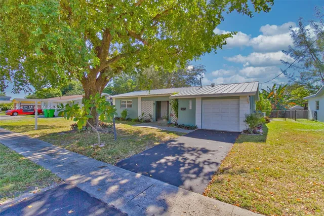 a view of a house with backyard and a tree