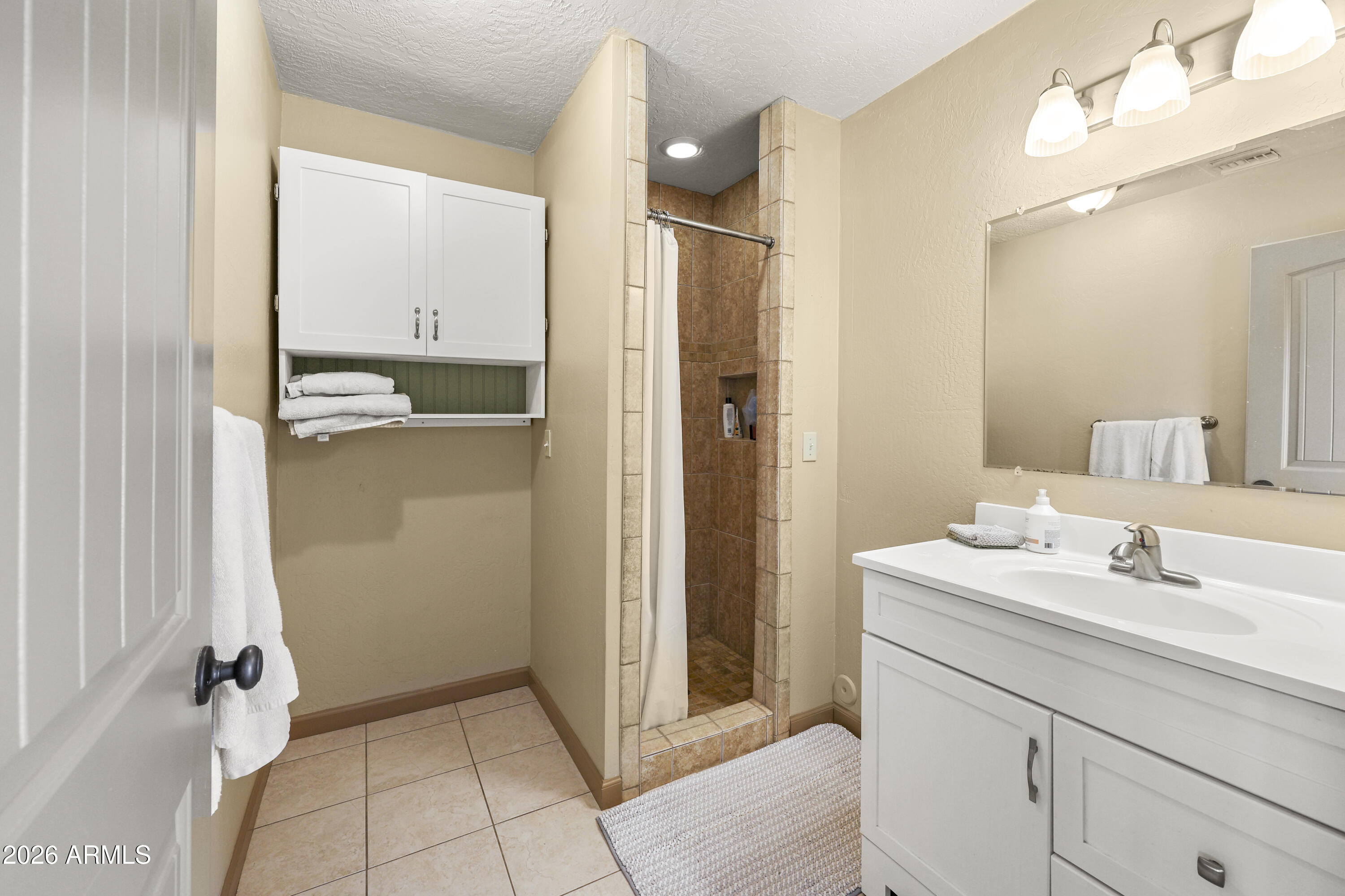 1890 West Roderick Lane Wickenburg, AZ 85390 - Photo 13 of 41 a bathroom with a sink a mirror and a shower