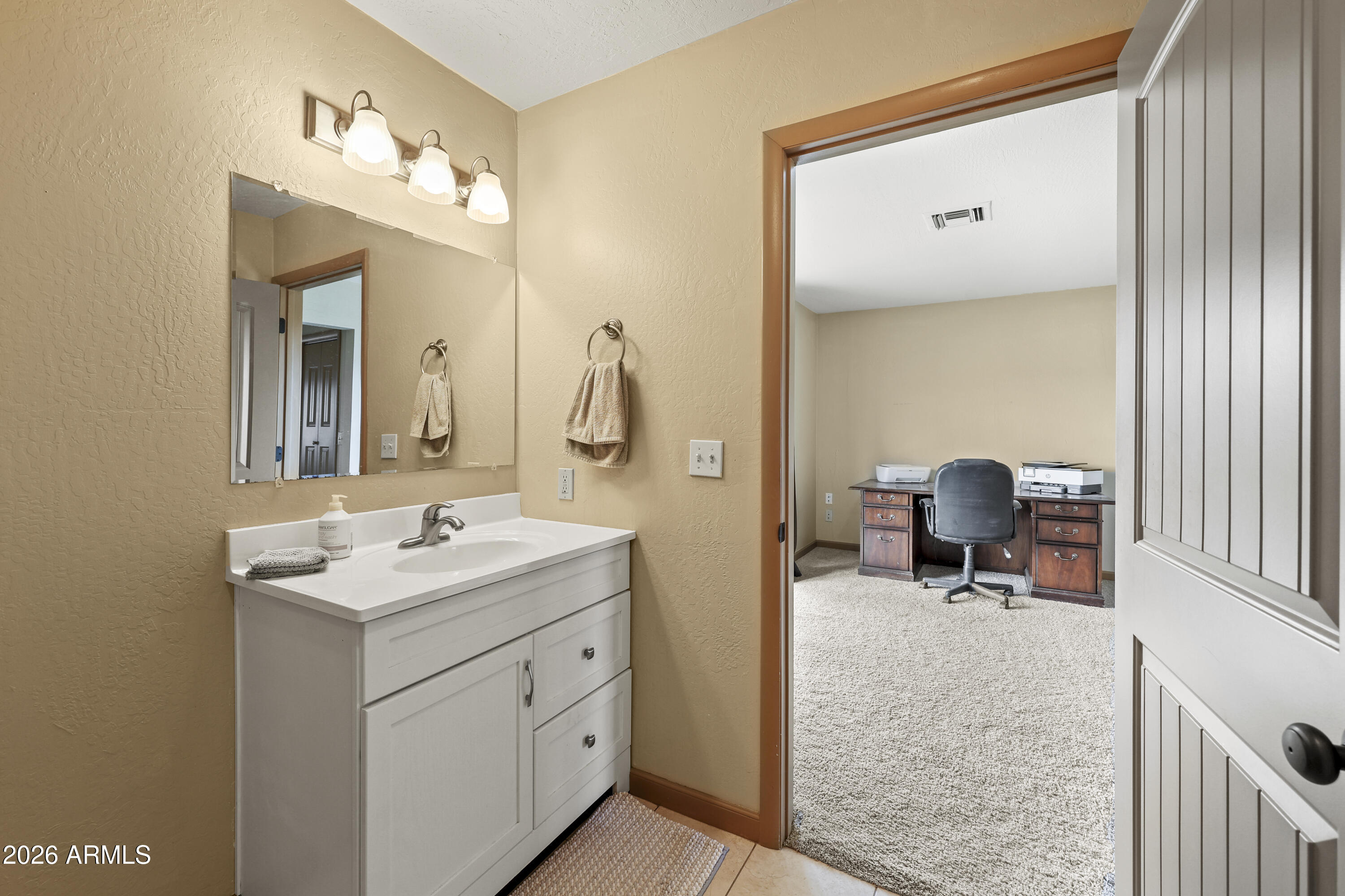 1890 West Roderick Lane Wickenburg, AZ 85390 - Photo 14 of 41 a en suite bathroom with a double vanity sink and a mirror
