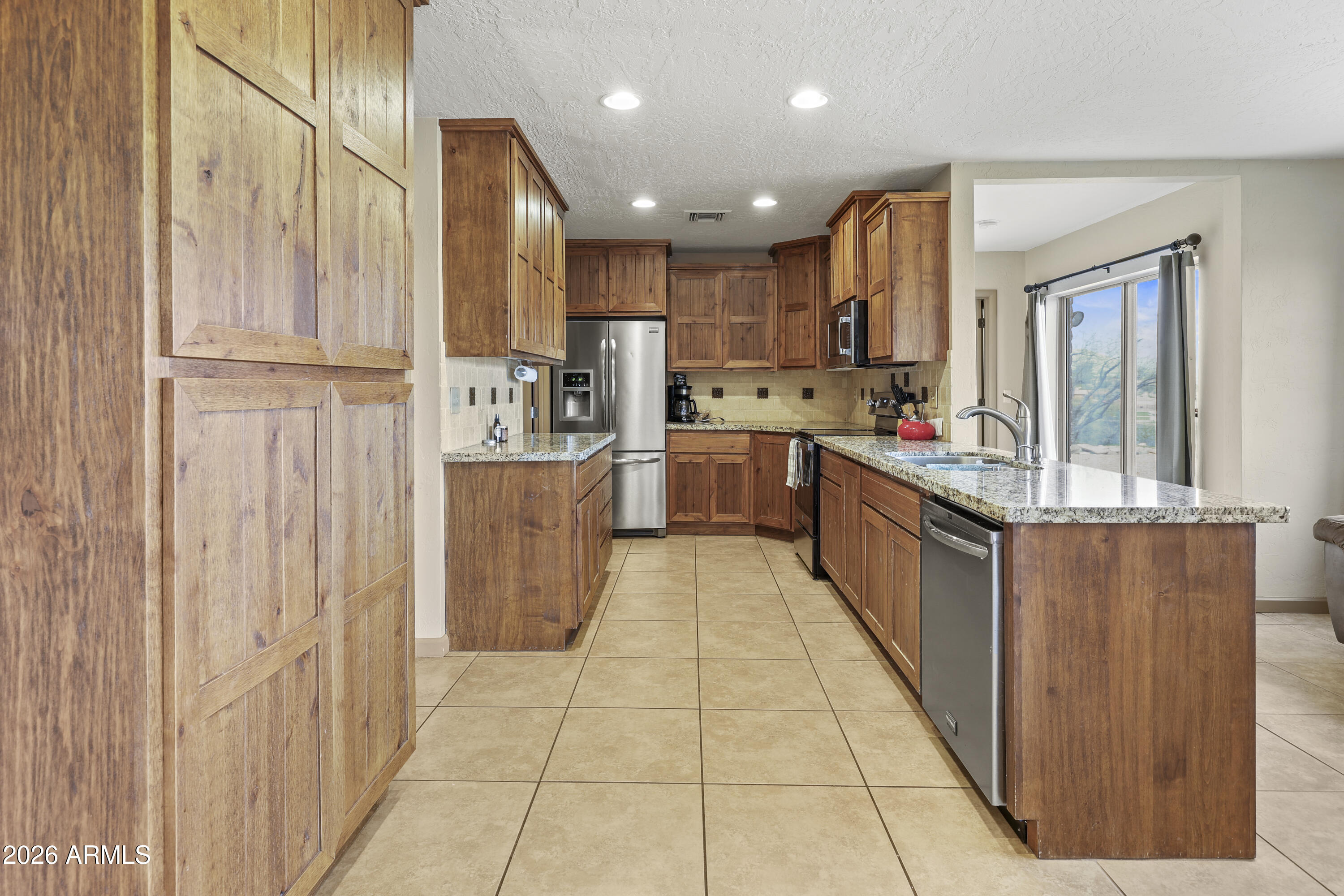 1890 West Roderick Lane Wickenburg, AZ 85390 - Photo 16 of 41 a kitchen with stainless steel appliances granite countertop a refrigerator and a stove