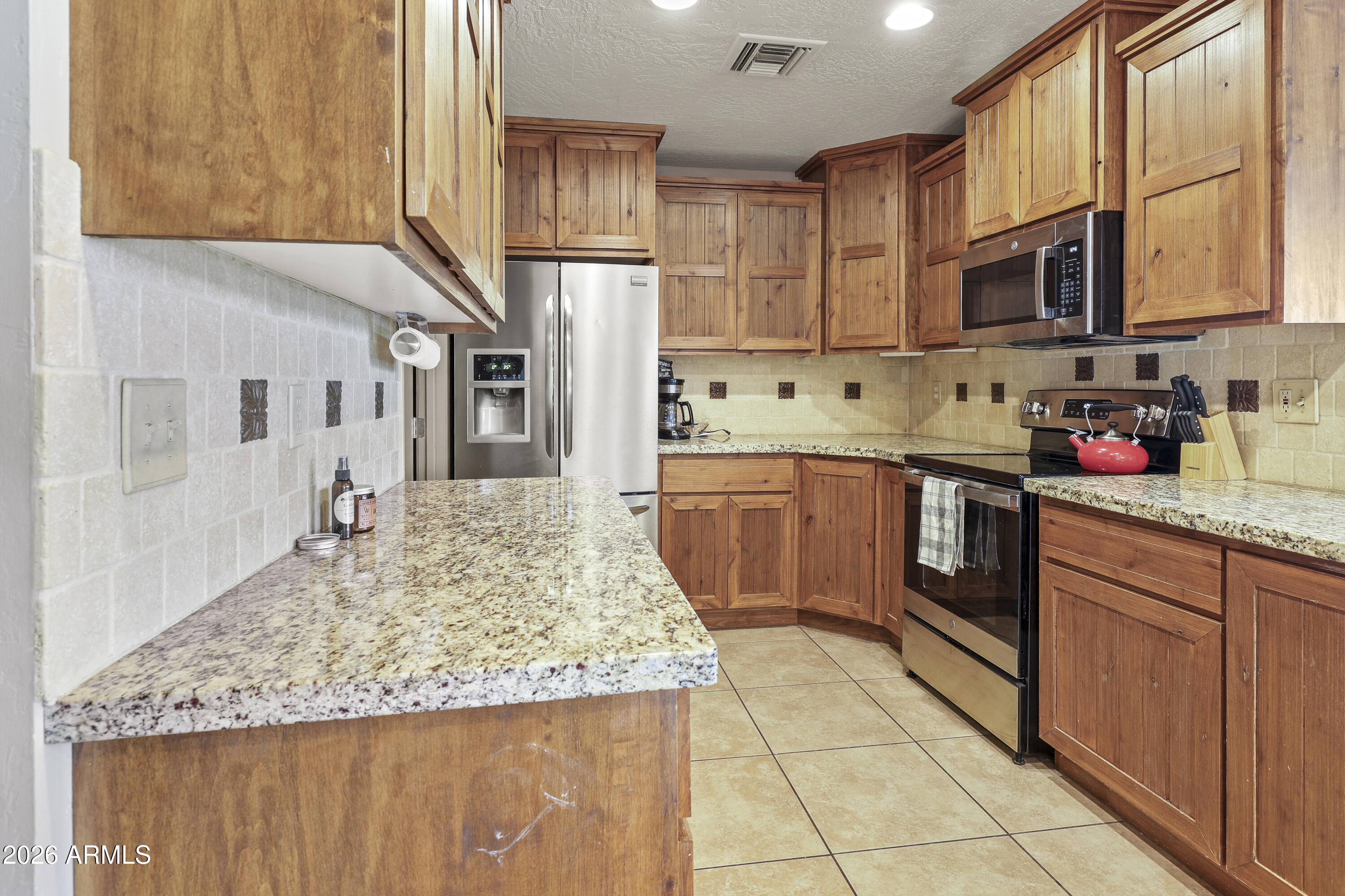 1890 West Roderick Lane Wickenburg, AZ 85390 - Photo 17 of 41 a kitchen with stainless steel appliances granite countertop a sink stove and refrigerator