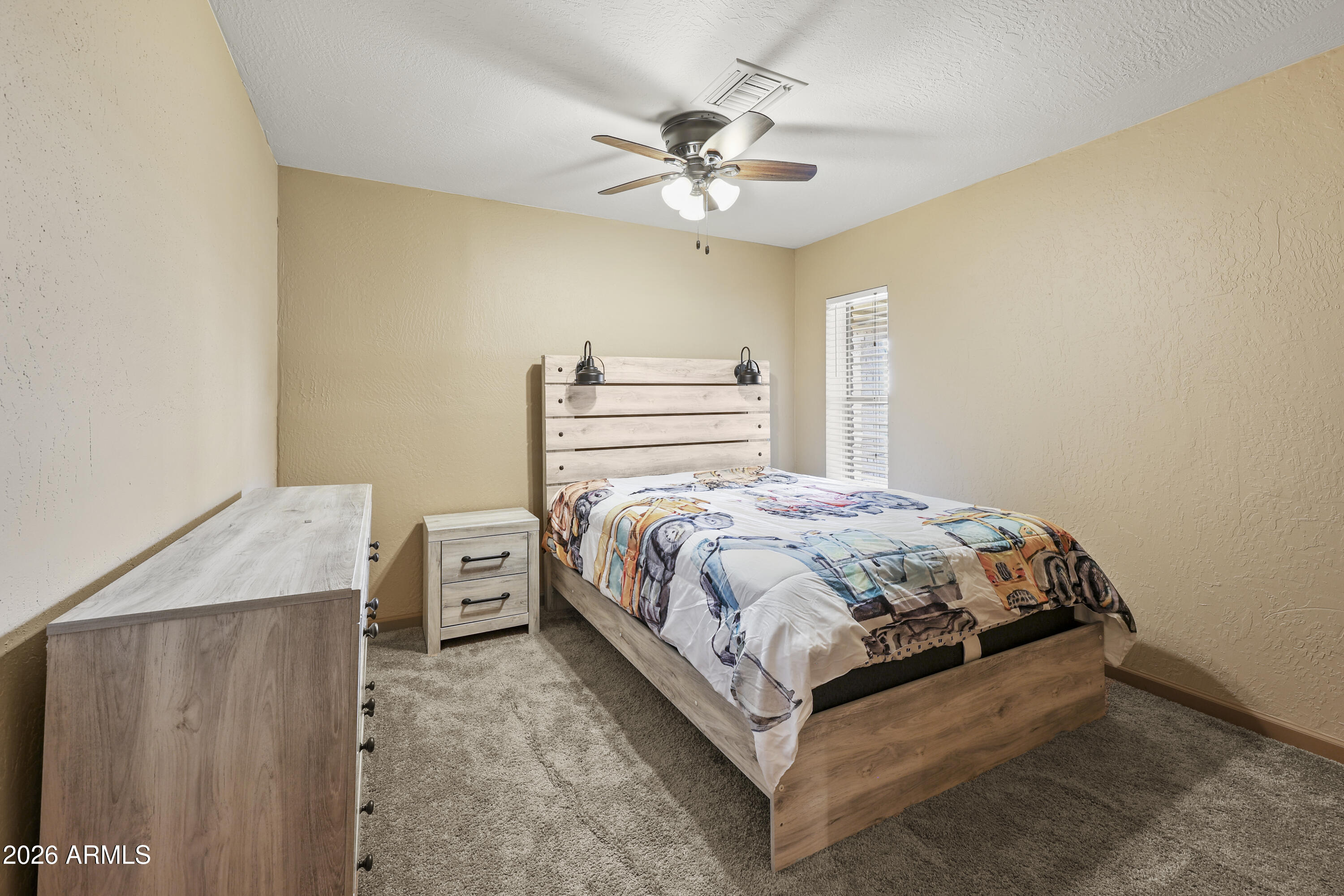 1890 West Roderick Lane Wickenburg, AZ 85390 - Photo 27 of 41 a bedroom with a bed and a chandelier