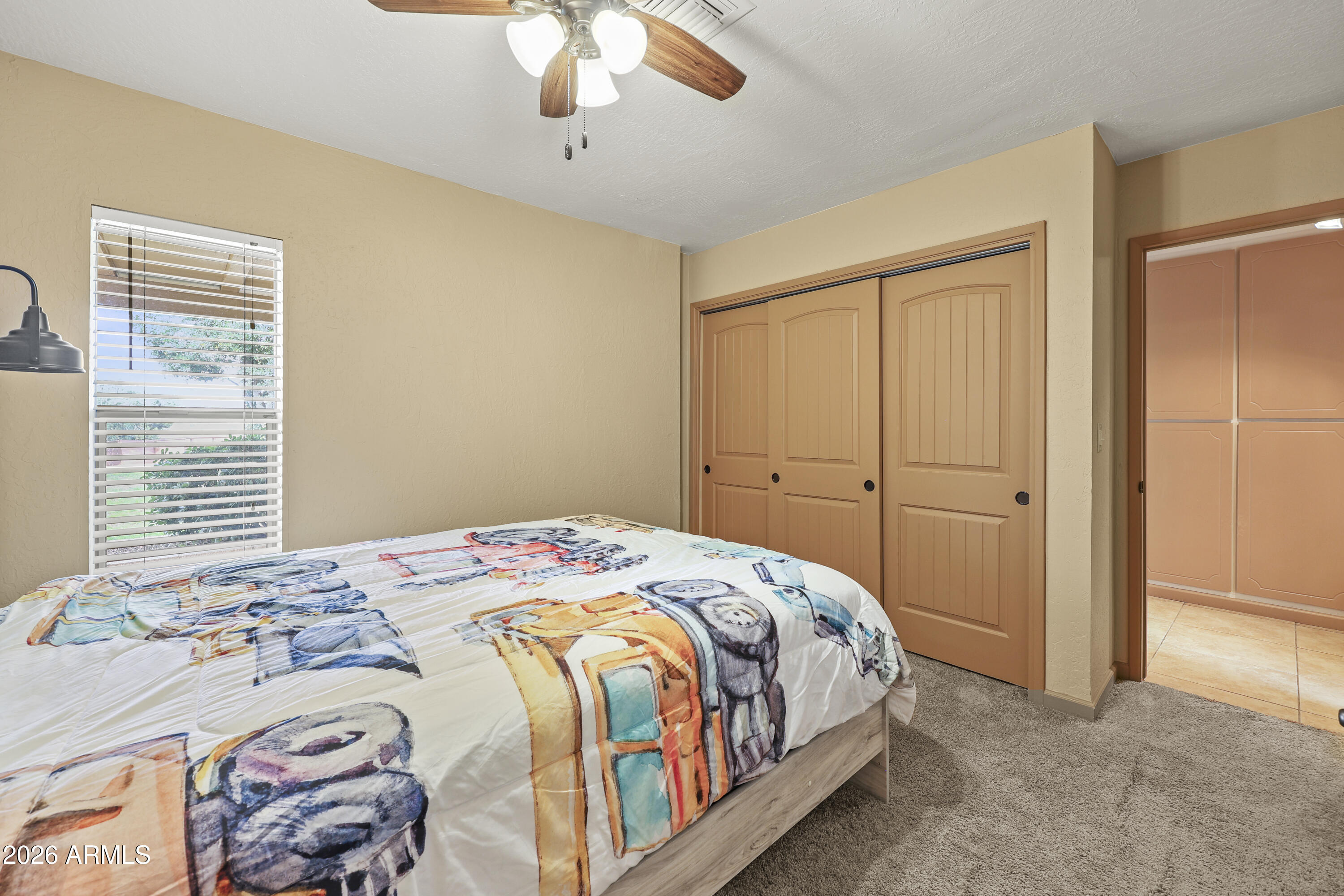 1890 West Roderick Lane Wickenburg, AZ 85390 - Photo 28 of 41 a bedroom with a bed and a chandelier