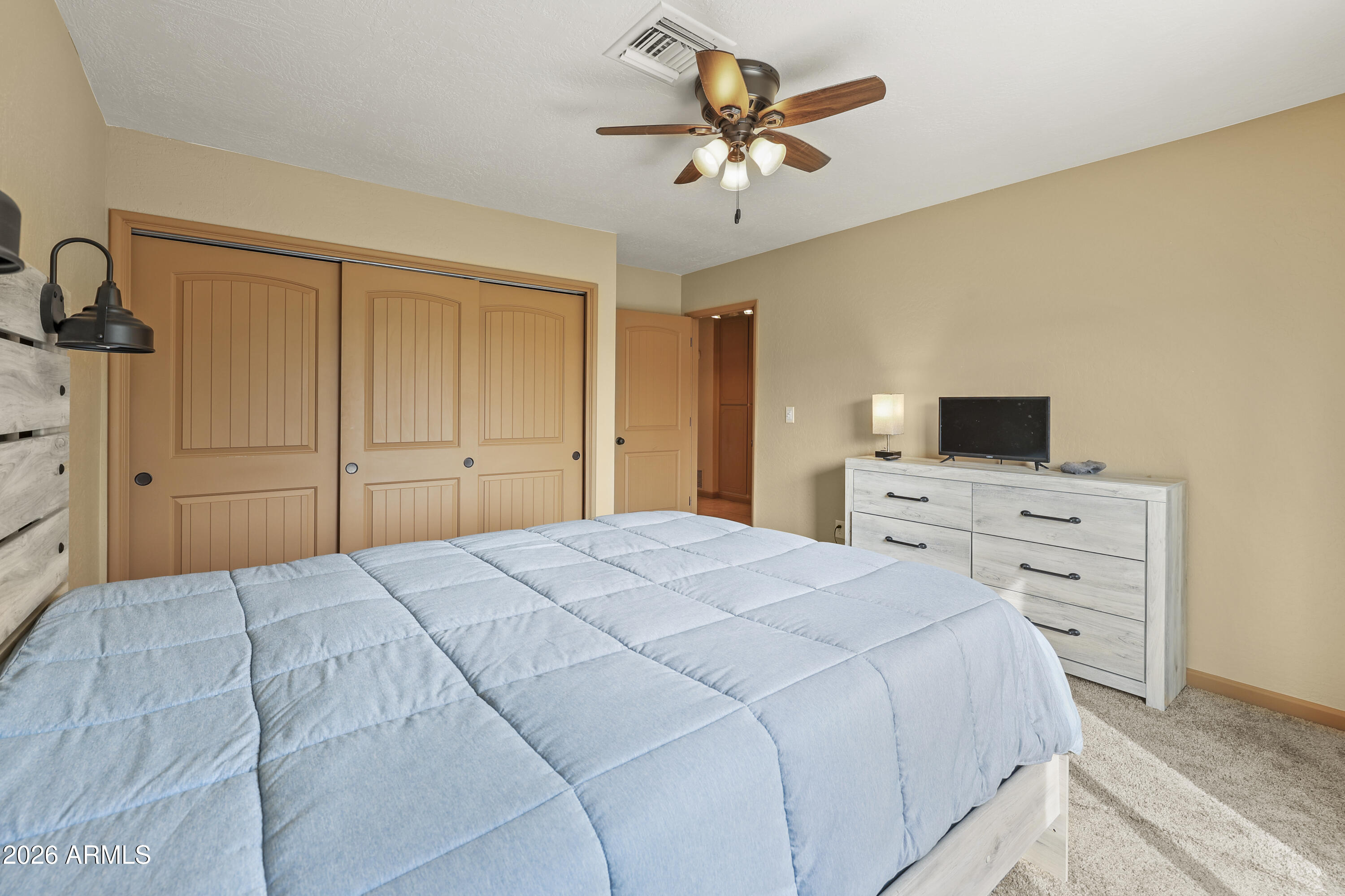 1890 West Roderick Lane Wickenburg, AZ 85390 - Photo 29 of 41 a bedroom with a bed and a tv on dresser