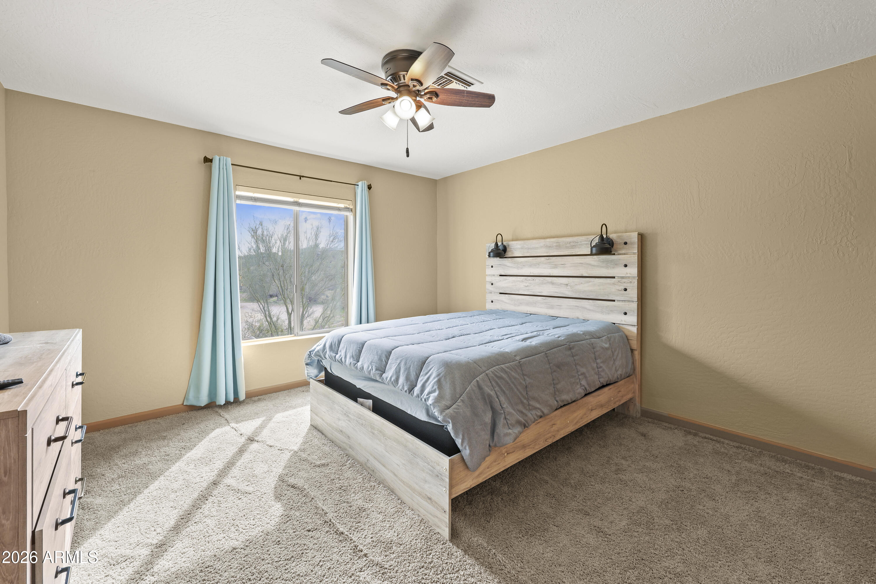 1890 West Roderick Lane Wickenburg, AZ 85390 - Photo 30 of 41 a bedroom with a large bed and a chandelier