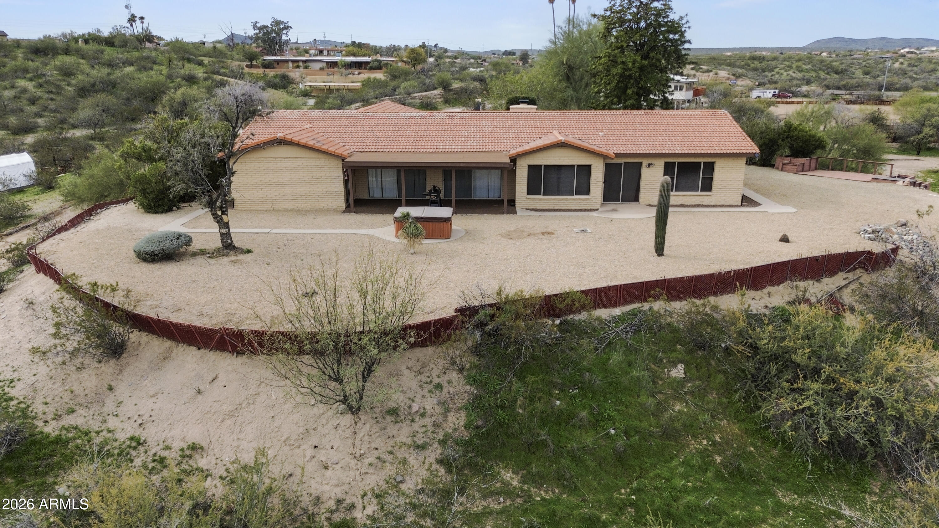 1890 West Roderick Lane Wickenburg, AZ 85390 - Photo 34 of 41 a view of a white house with a swimming pool and lawn chairs under an umbrella