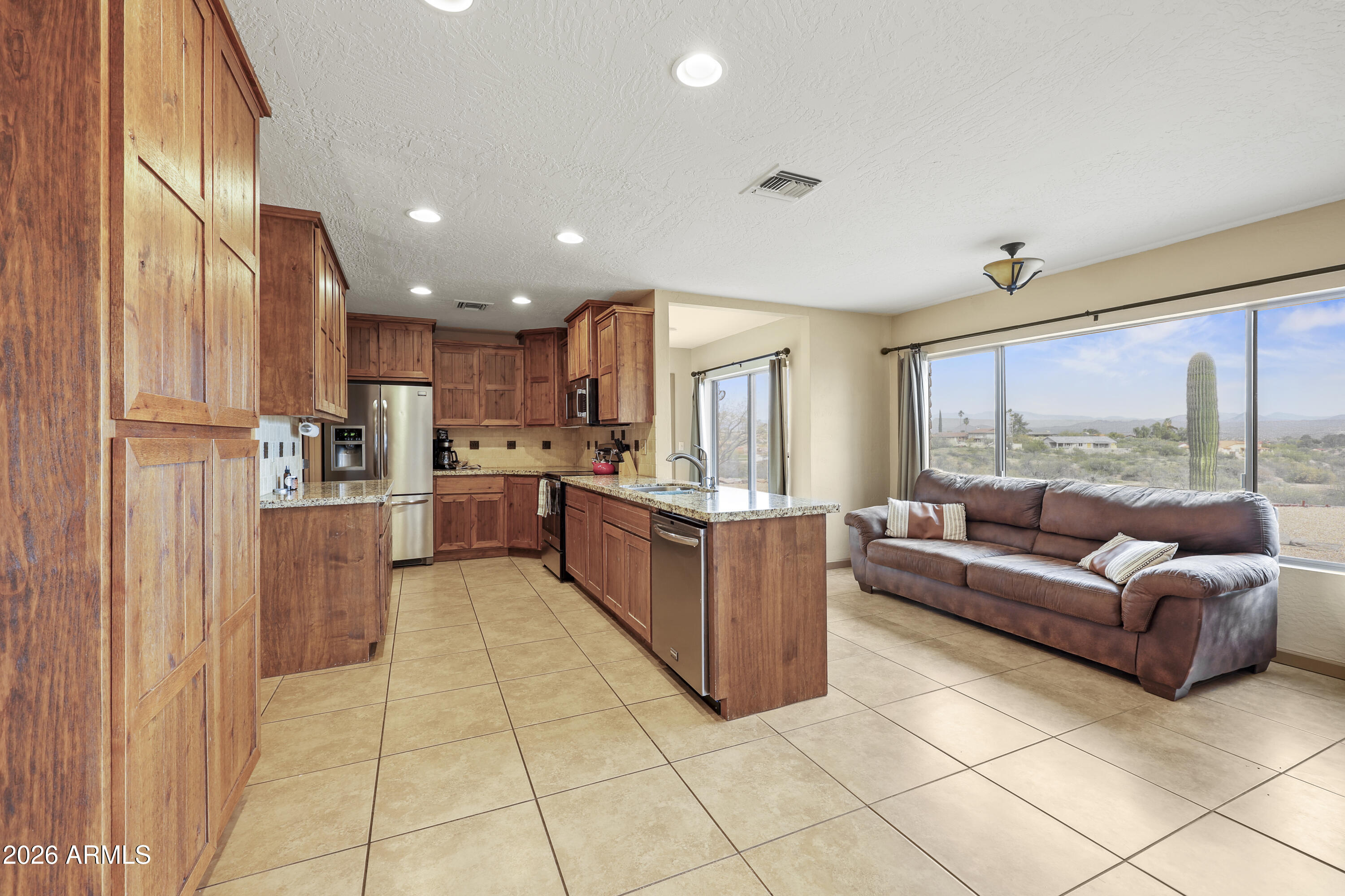 1890 West Roderick Lane Wickenburg, AZ 85390 - Photo 9 of 41 a kitchen with stainless steel appliances granite countertop a refrigerator and a stove top oven
