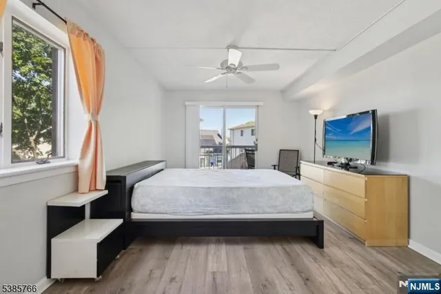 a spacious bedroom with a bed and a flat screen tv