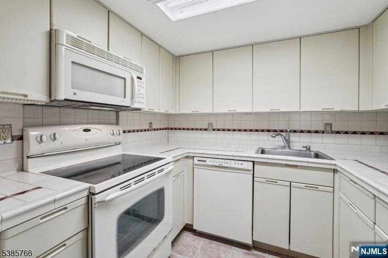 38 Moonachie Road, Unit 116 Hackensack, NJ 07601 - Photo 3 of 19 a kitchen with white cabinets and white appliances