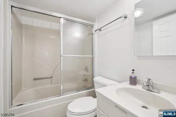 a bathroom with a bathtub shower sink vanity and toilet