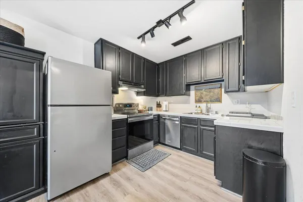 a kitchen with a sink cabinets and stainless steel appliances