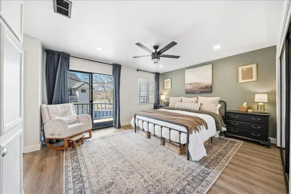 a spacious bedroom with a bed and wooden floor