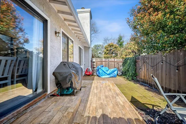 a view of backyard with wooden fence and trees in the background