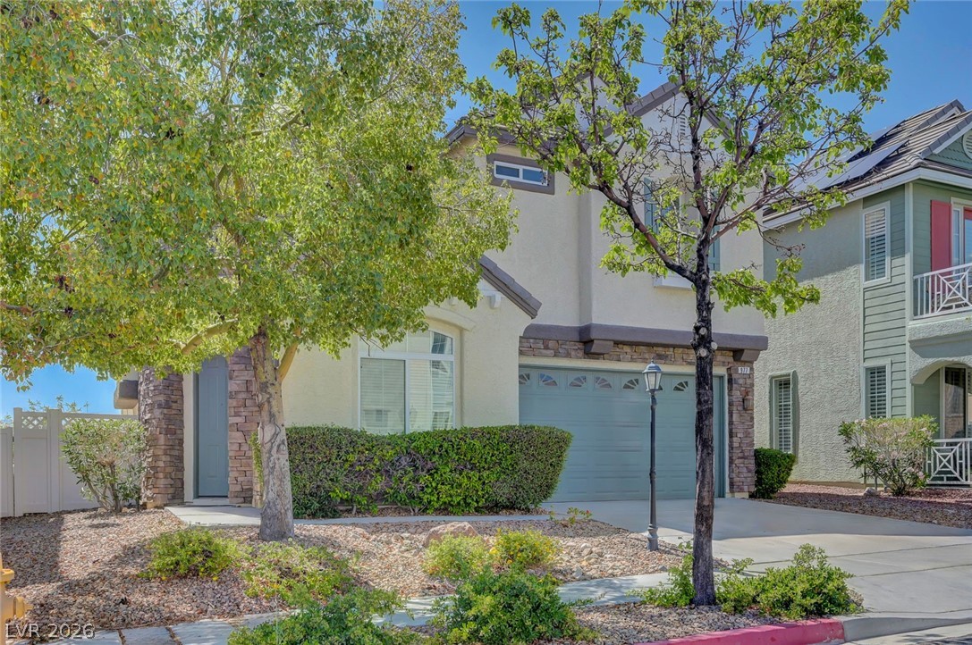 977 Sparkling Light Street Henderson, NV 89052 - Photo 14 of 75 This two-story residence features a manicured lawn and an inviting entrance with a paved driveway.