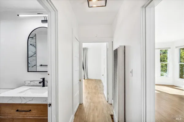 a view of an empty room with wooden floor and a window