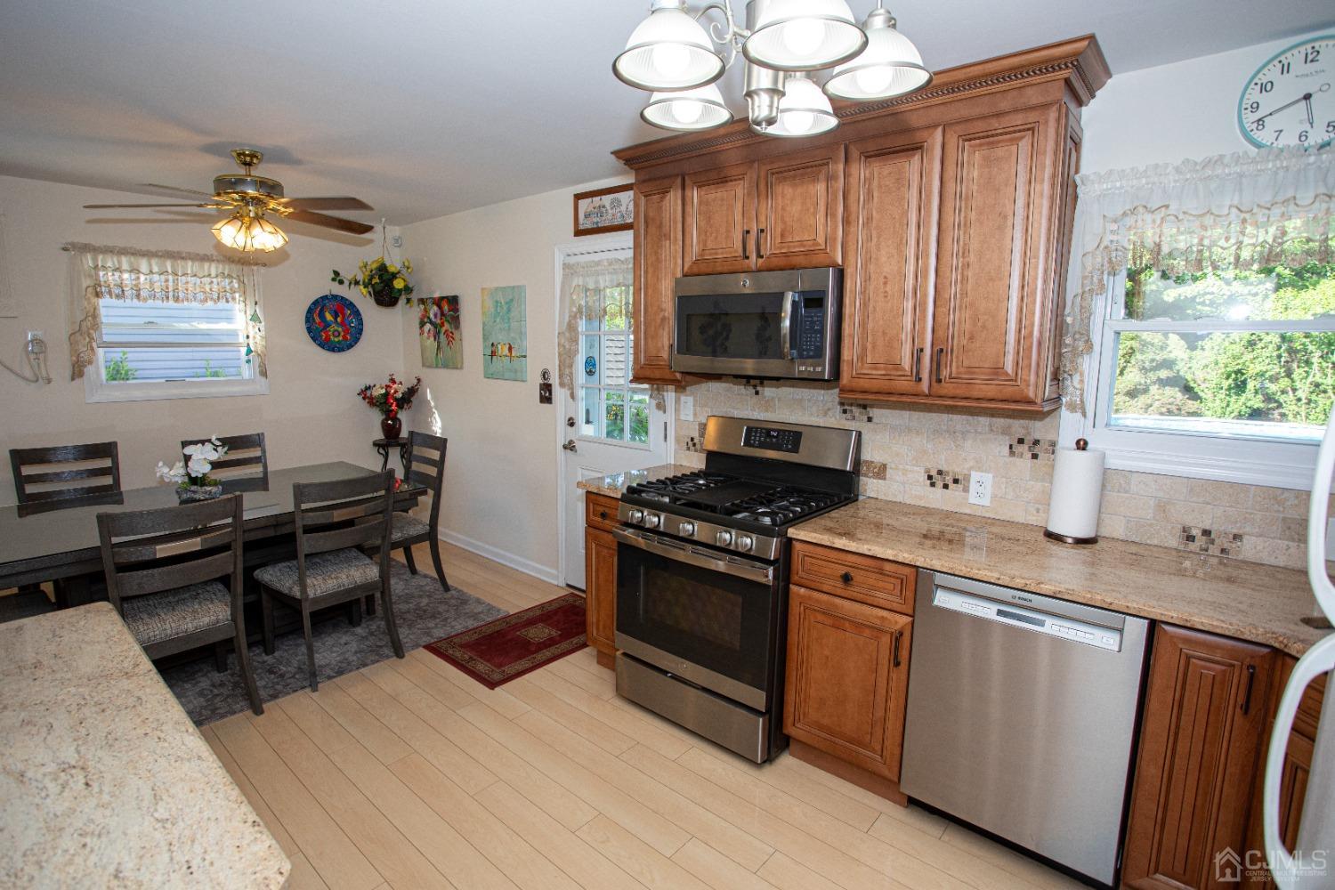 25 Finley Road Edison, NJ 08817 - Photo 22 of 51 a kitchen with stainless steel appliances granite countertop a stove top oven a sink dishwasher and wooden cabinets