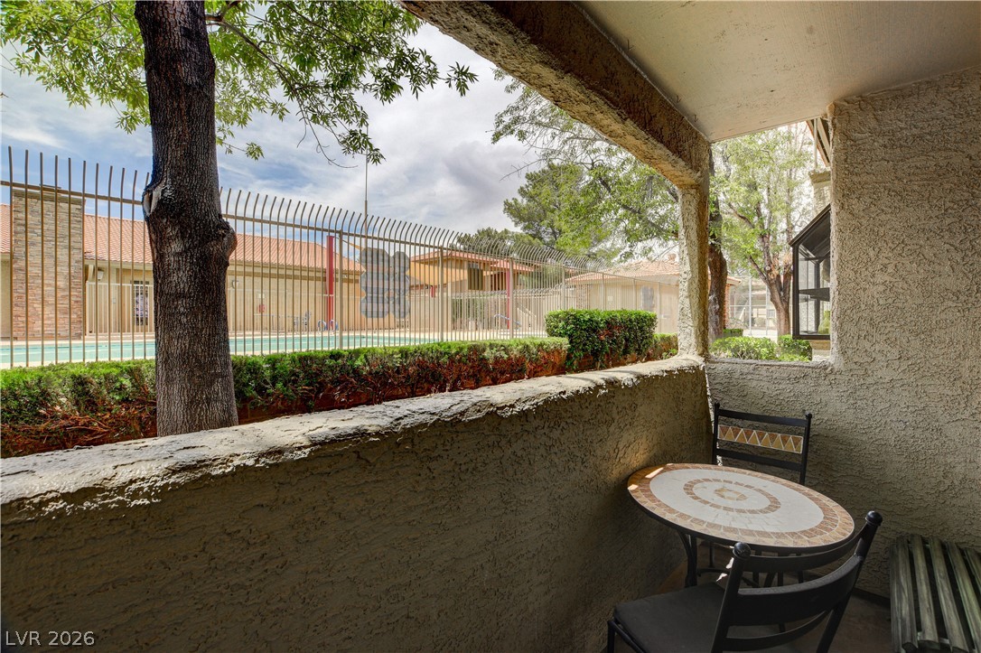 7200 West Pirates Cove Road, Unit 1026 Las Vegas, NV 89145 - Photo 27 of 35 This inviting patio space offers direct views of the community pool and lush greenery.