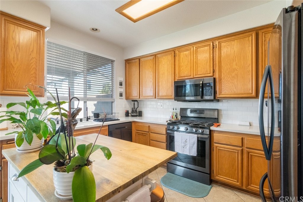 5624 Pheasant Drive Fontana, CA 92336 - Photo 7 of 20 a kitchen with stainless steel appliances granite countertop sink stove top oven and cabinets