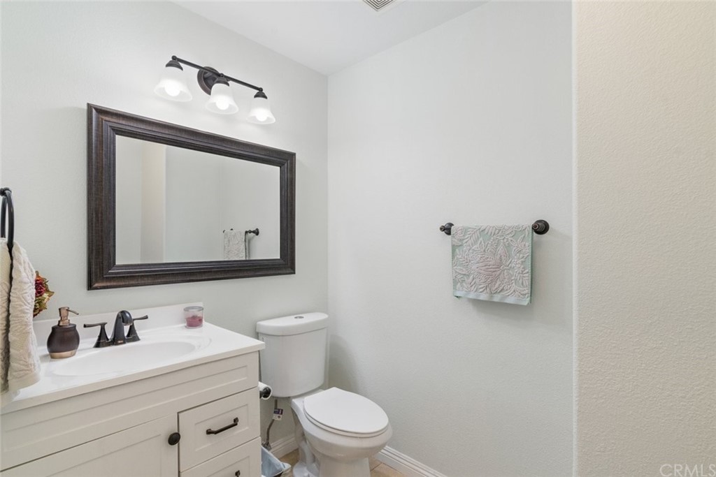 5624 Pheasant Drive Fontana, CA 92336 - Photo 8 of 20 a bathroom with a toilet sink vanity and mirror