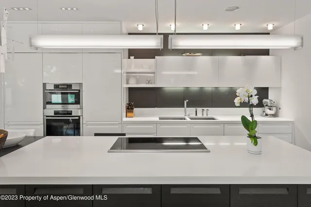 a kitchen with a sink a stove and chairs