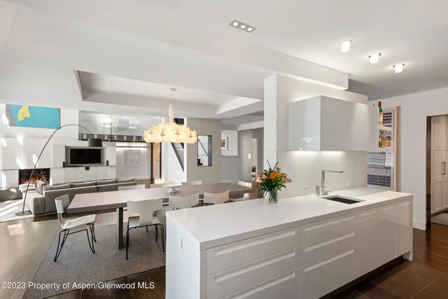 a room with kitchen island a white cabinets and chair