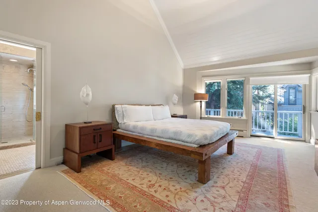 a spacious bedroom with a bed and large window