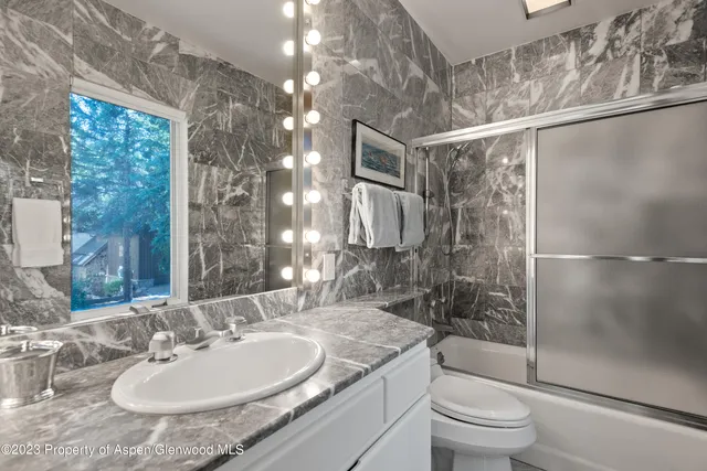 a bathroom with a sink granite toilet and shower