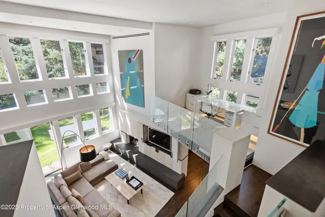 a living room with furniture fireplace and a large window