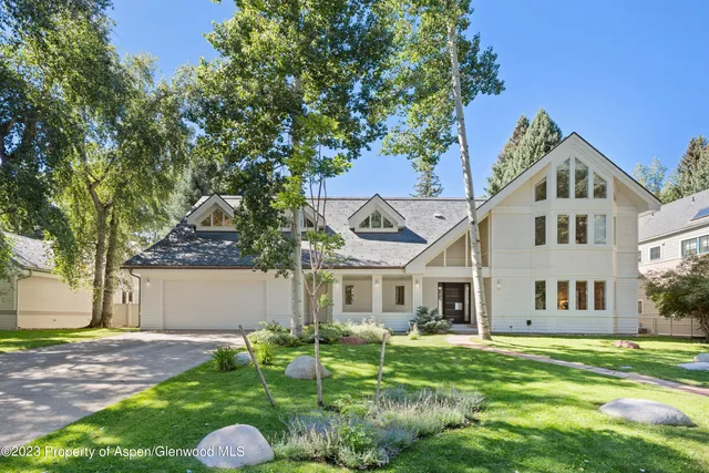 a front view of a house with a yard and trees
