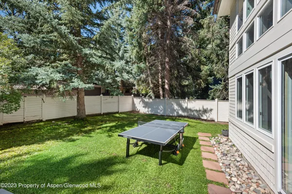a view of a backyard with wooden fence and a bench