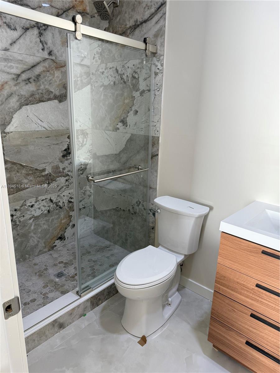 2273 Phoenix Avenue Davie, FL 33324 - Photo 12 of 20 a white toilet sitting next to a bath tub and a shower