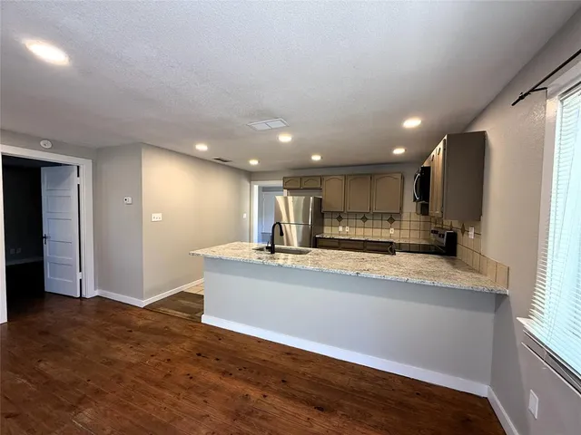 a view of kitchen with stainless steel appliances refrigerator sink and cabinets