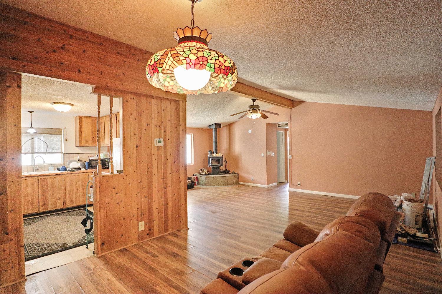 25433 East Trimmer Springs Road, Unit 4 Sanger, CA 93657 - Photo 2 of 33 a living room with couches a dining table and chairs with wooden floor