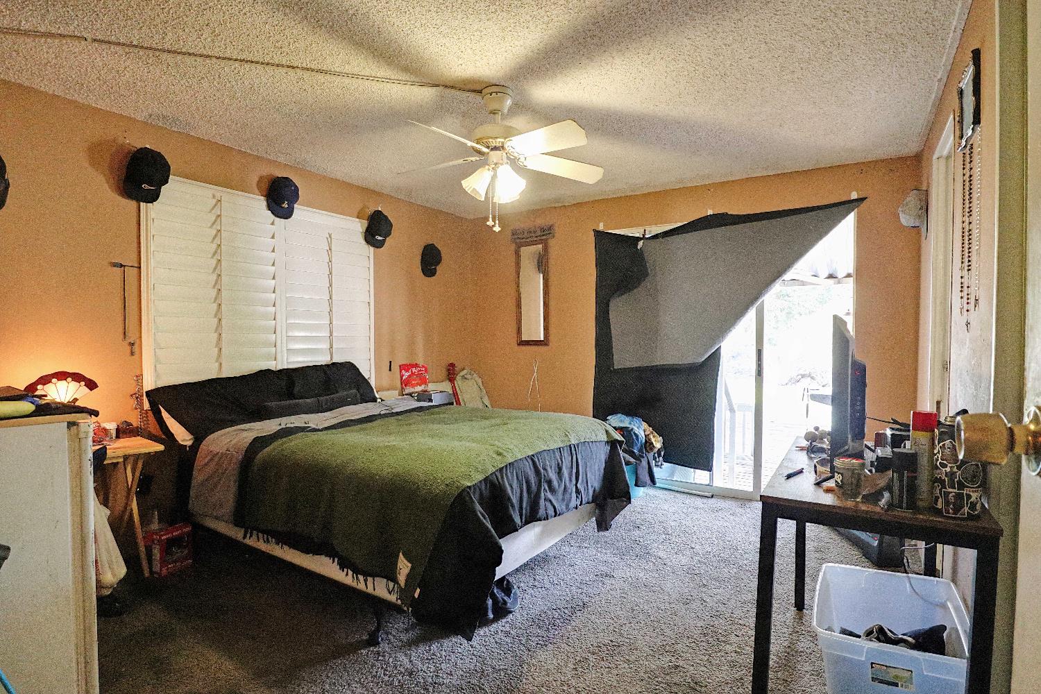 25433 East Trimmer Springs Road, Unit 4 Sanger, CA 93657 - Photo 4 of 33 a bedroom with a bed and a chandelier